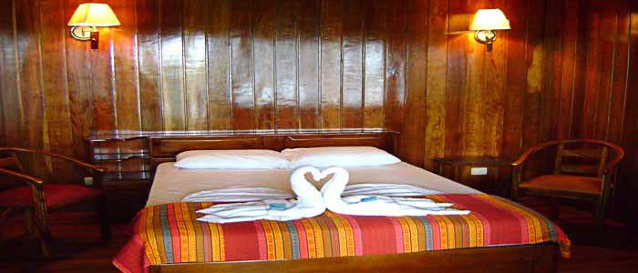 Miss Junie's (Iguana Verde Lodge) - Chambre Hotel Miss Junie's Iguana Verde chambre bois lit double chaises