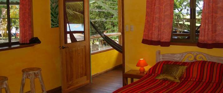 Café de la Suerte - Chambre lit, chaleureux, frigo, lampe, hamac, rideau, terrasse, table de nuit, hôtel, cabinas, pavones, pacifique sud, surf, plage