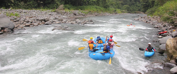 descente en rafting d'un groupe, rivière avec rapide et kayak de sécurité