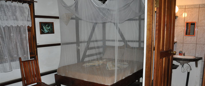 Chambre Coco Logo Lodge Caraïbes Sud Puerto viejo de Talamanca chambre en bois rustique avec lit double moustiquaire salle de bain