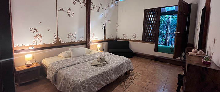 Chilamate Rainforest Ecolodge Retreat - chambre spacieuse avec lit double, papier peint fleuri minimaliste au mur
