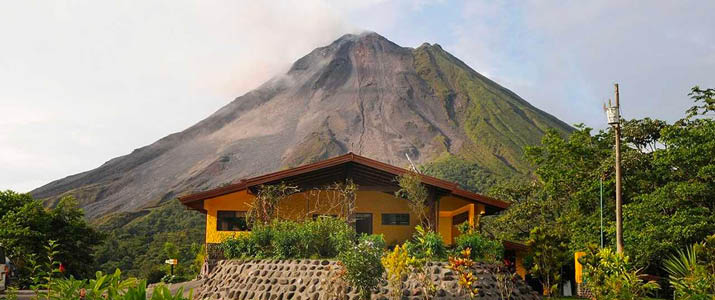 Vue extérieure d'une villa avec volcan en fond